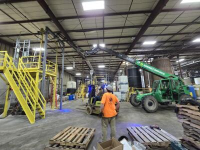 Custom steel mixer platform with a guillotine style gate and Hoist Frame. Designed, engineered, fabricated and installed by M&M